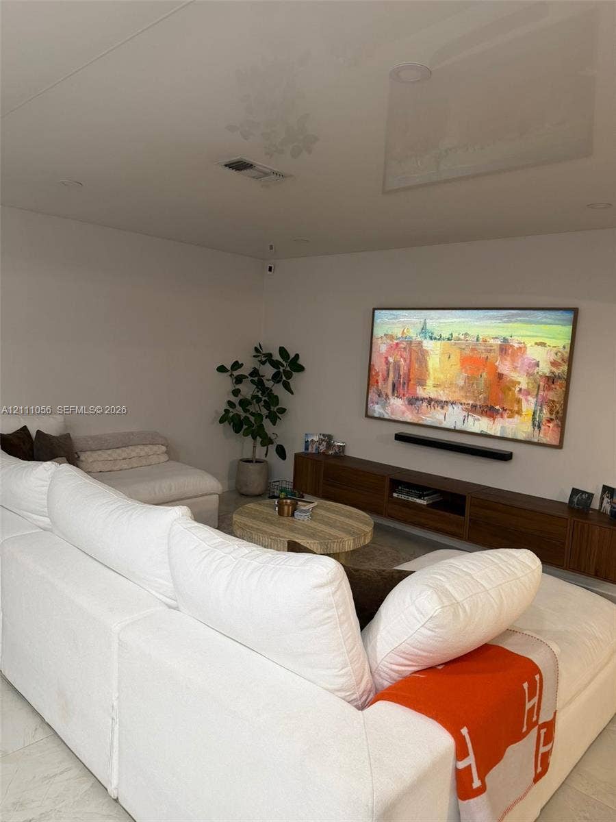 5020 Sheridan Street, #2, Hollywood, FL 33021 Wall-mounted wood-finish media console, recessed ceiling lighting, and neutral stone-finish flooring