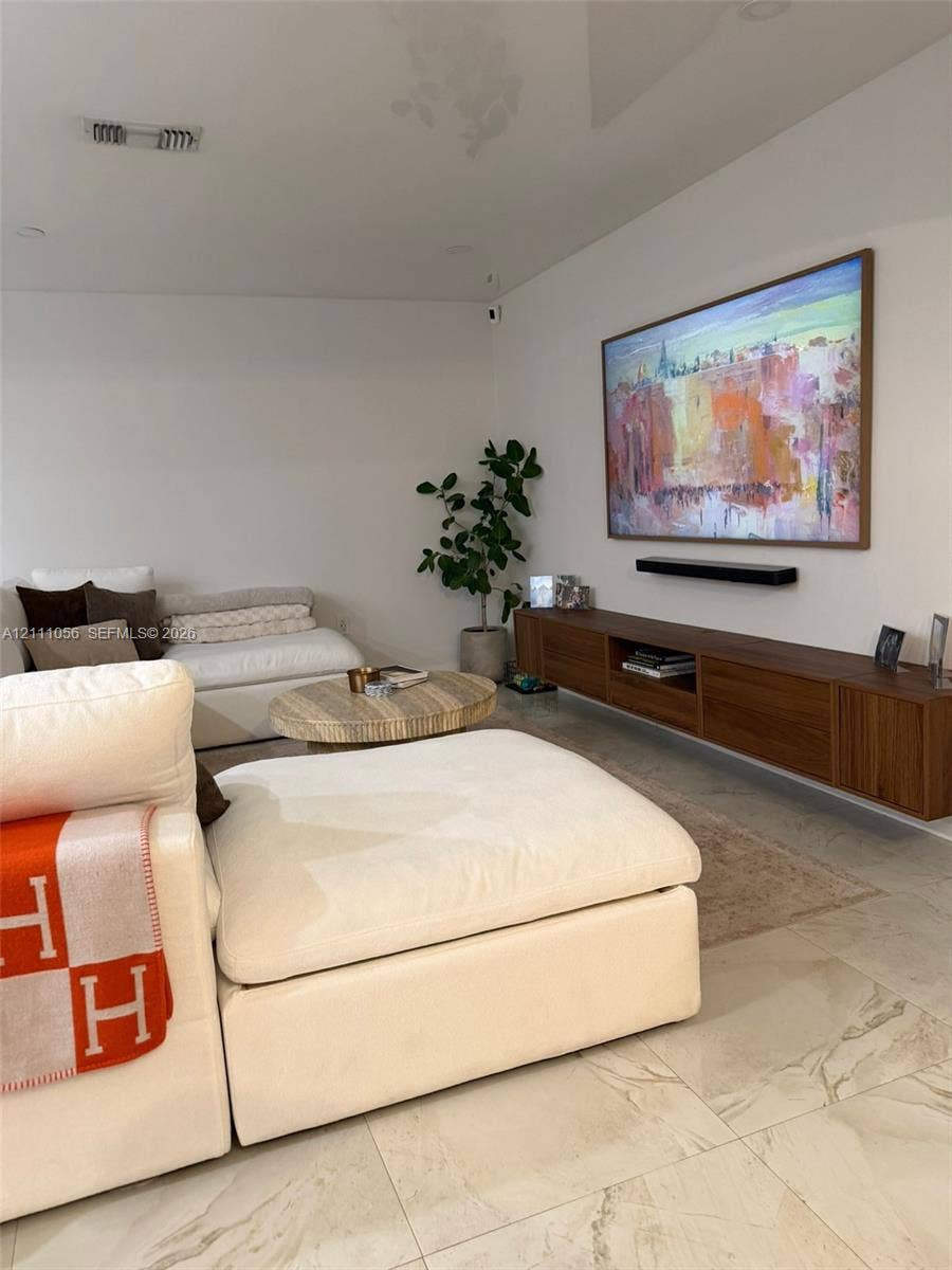 5020 Sheridan Street, #2, Hollywood, FL 33021 Wall-mounted walnut media console, recessed lighting, and large-format stone tile flooring