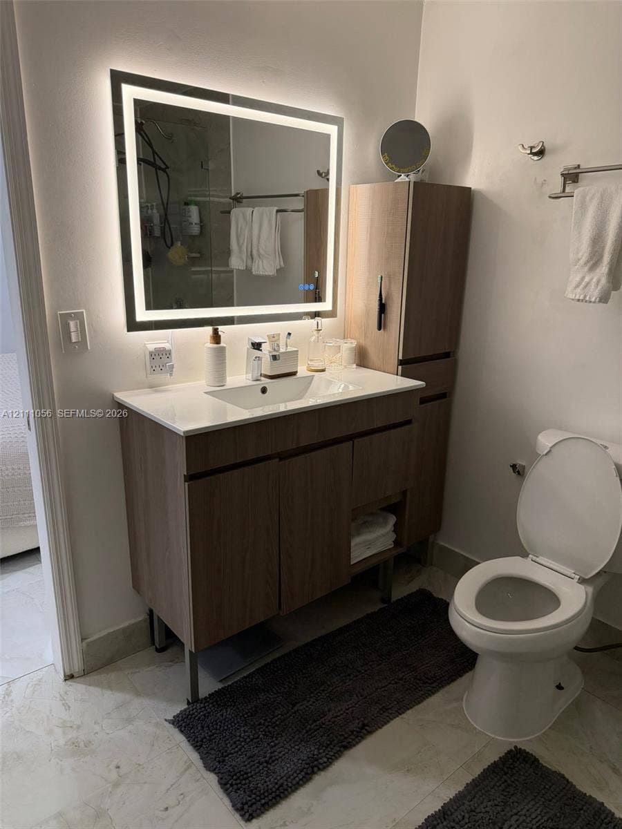 5020 Sheridan Street, #2, Hollywood, FL 33021 Large-format, stone-finish floor tiling with neutral veining, paired with white interior doors featuring classic panel detailing and polished metal hardware