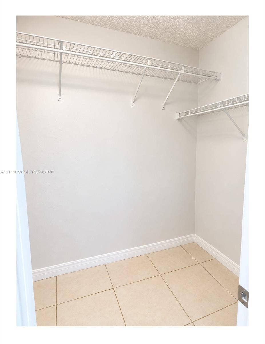 Storage area featuring ceramic tile flooring and multi-level white wire shelving