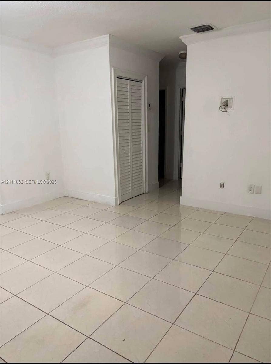 17631 32nd Court, Miami Gardens, FL 33056 Neutral-toned tile flooring, crown molding, and louvered closet doors