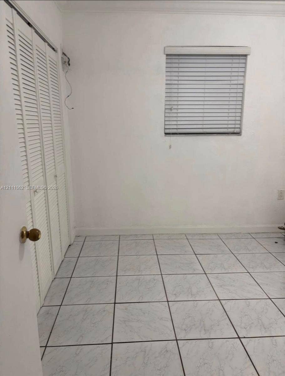 17631 32nd Court, Miami Gardens, FL 33056 Tile flooring, bi-fold louvered closet doors, and window with fitted blinds