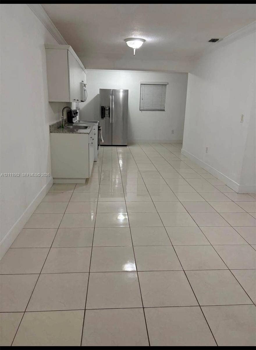 17631 32nd Court, Miami Gardens, FL 33056 Kitchen featuring white cabinetry, stone-finish countertops, stainless steel refrigerator, and ceramic tile flooring