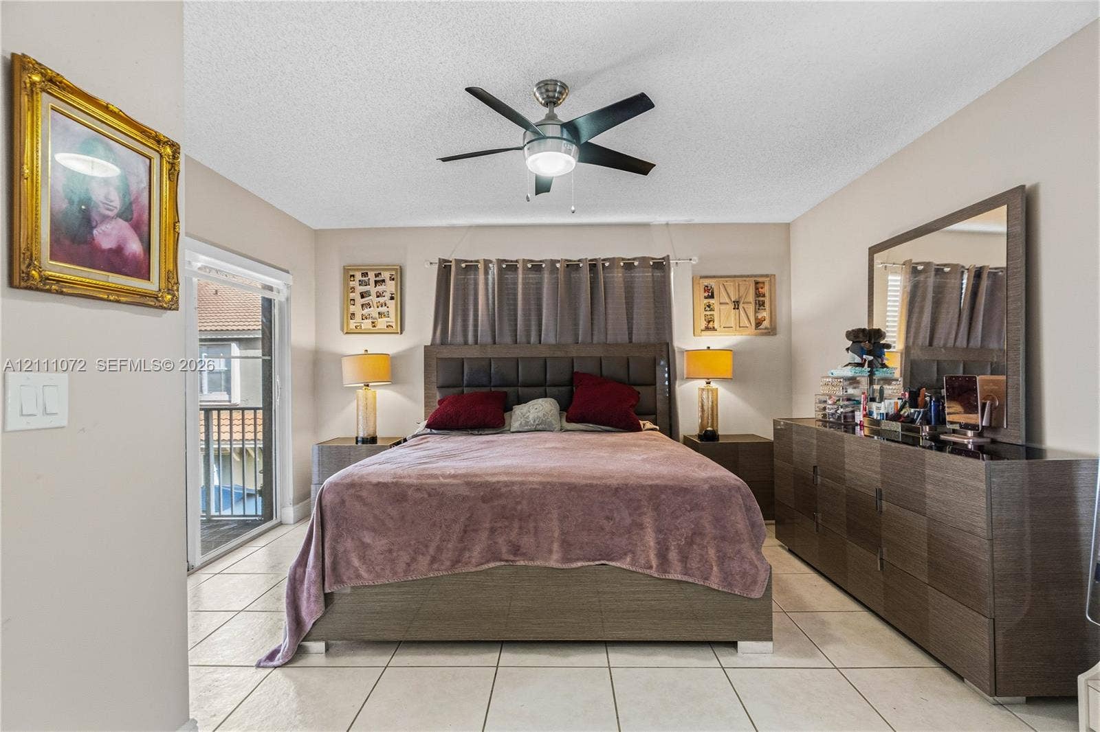 Interior space featuring tile flooring, a central ceiling fan with integrated lighting, and a glass sliding door leading to an exterior balcony