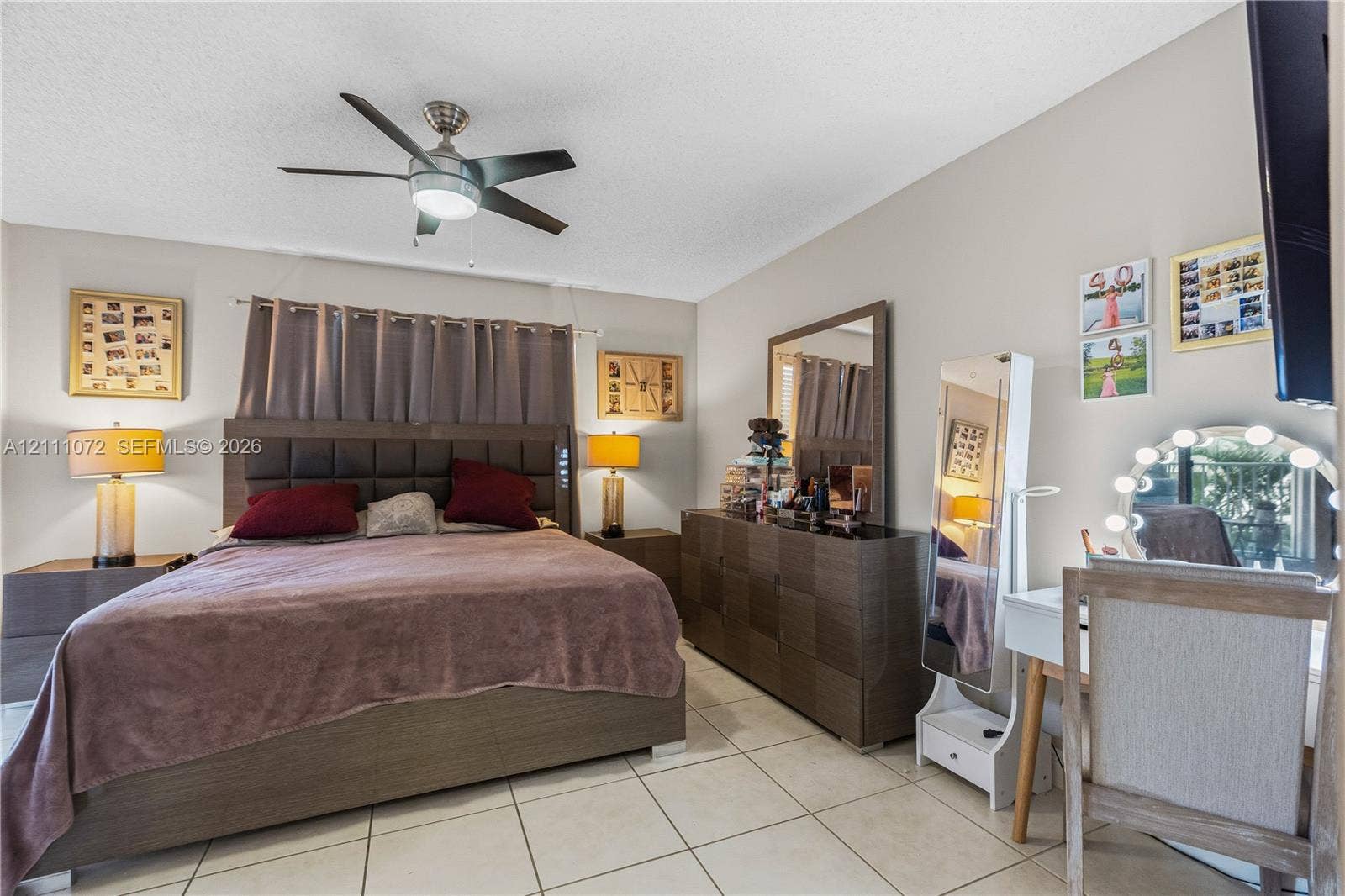 Neutral-toned room featuring large-format tile flooring and a ceiling-mounted fan with integrated lighting
