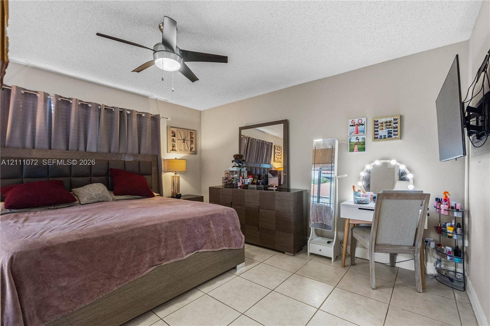 Spacious room featuring neutral wall tones, ceramic tile flooring, and a brushed nickel ceiling fan with integrated lighting