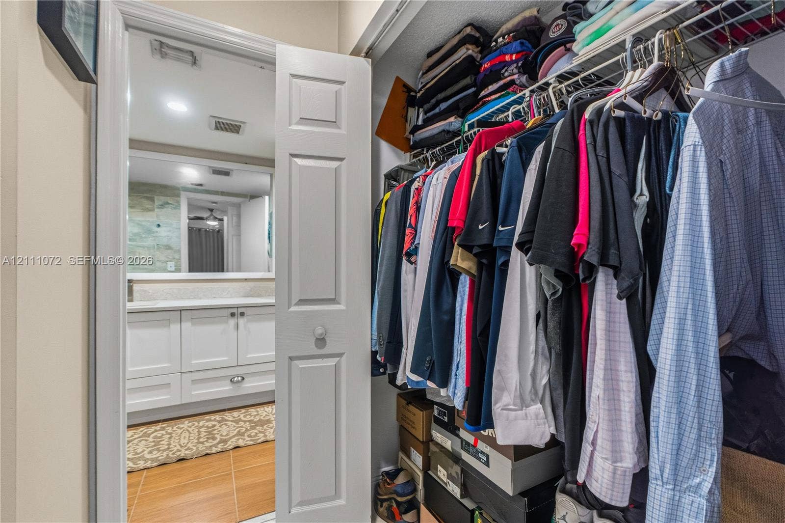 Storage closet featuring wire shelving, bifold door, and tile flooring