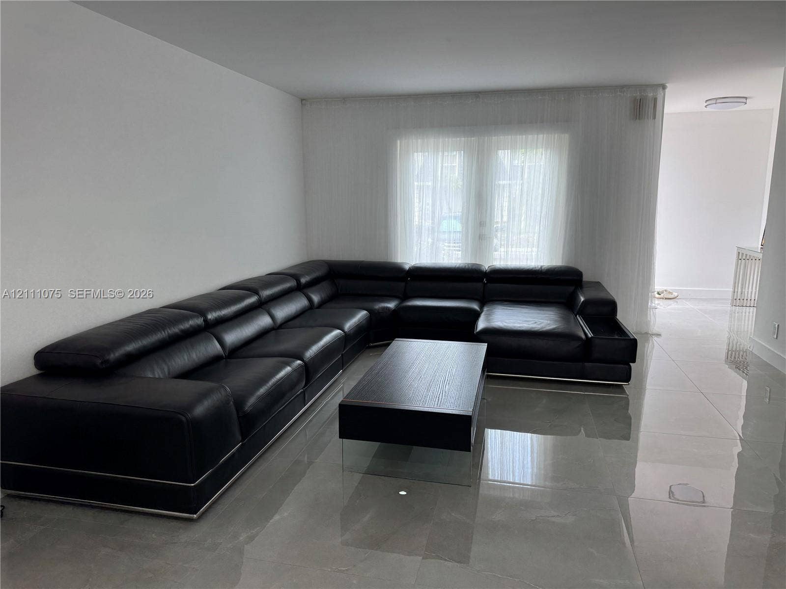 2318 NE 7th Street, #34, Hallandale Beach, Hallandale Beach, FL 33009 Large format light-colored tile flooring, double glass panel doors, and neutral wall tones