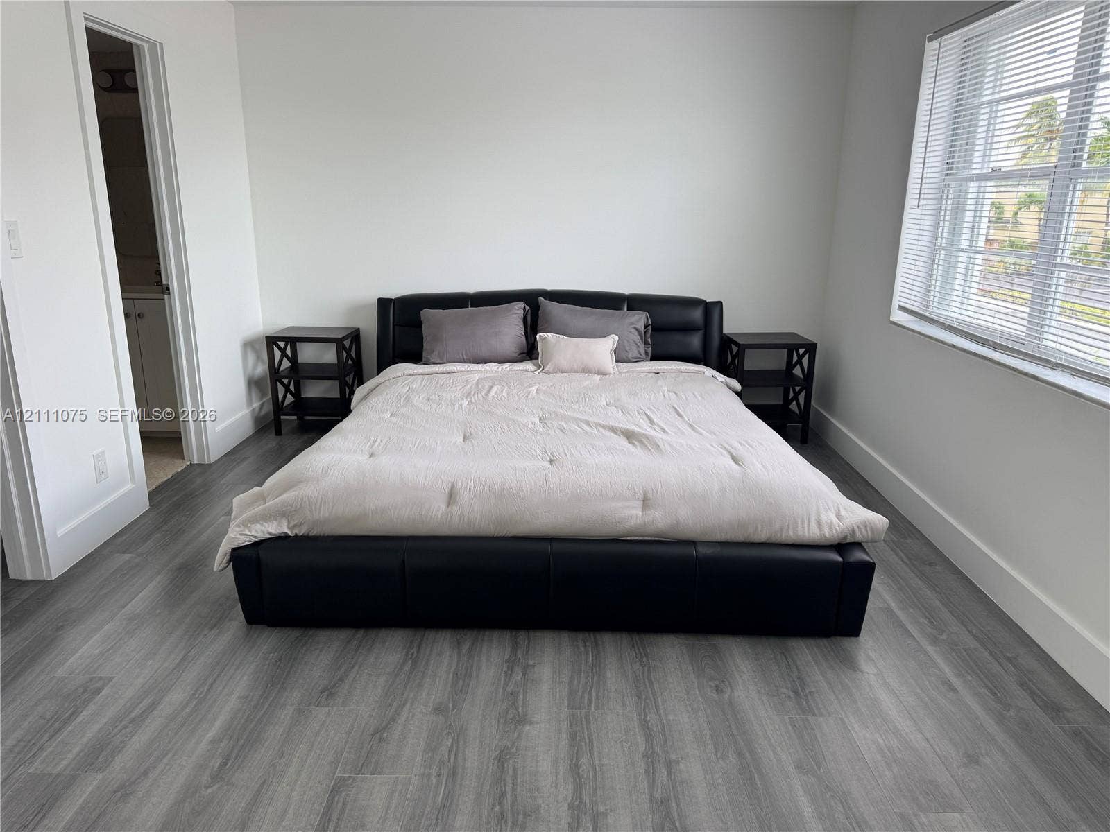2318 NE 7th Street, #34, Hallandale Beach, Hallandale Beach, FL 33009 Room featuring wood-finish flooring, neutral walls, and a window with horizontal blinds