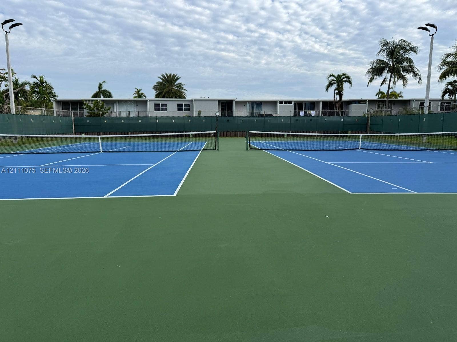 2318 NE 7th Street, #34, Hallandale Beach, Hallandale Beach, FL 33009 Dual tennis courts featuring high-contrast surfacing, perimeter fencing, and pole-mounted court lighting
