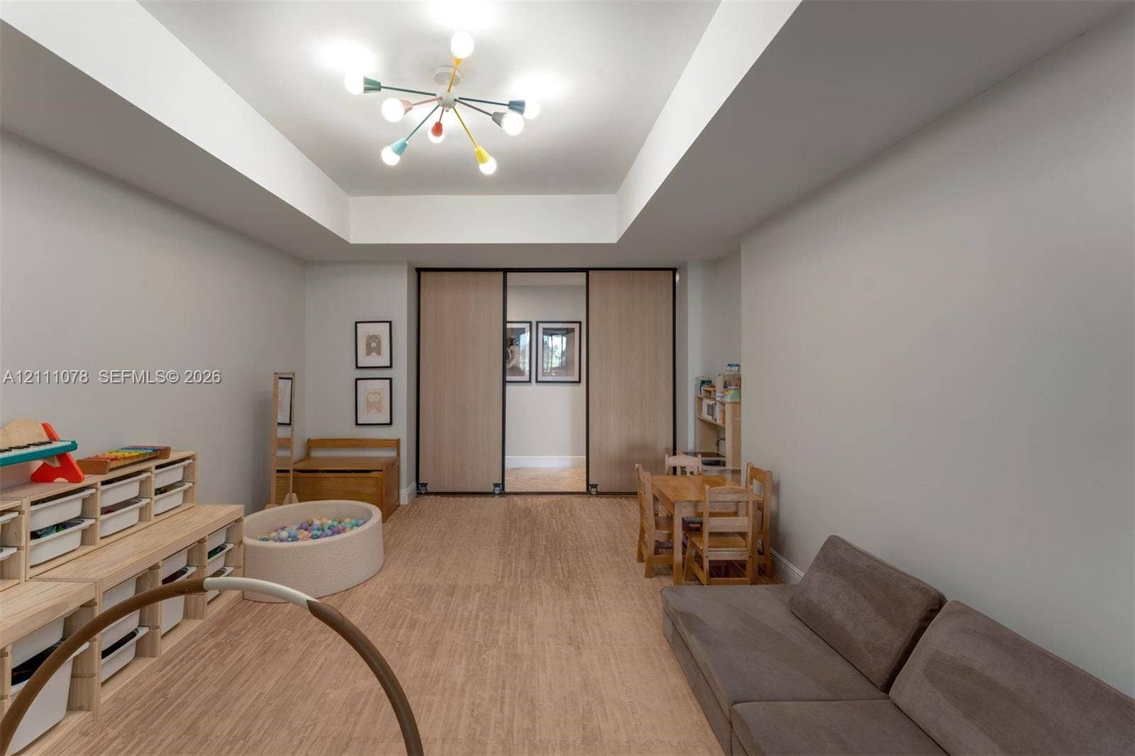 765 Crandon Boulevard, #311, Key Biscayne, FL 33149 Interior space featuring a recessed tray ceiling, wood-finish flooring, and large sliding doors with dark frames