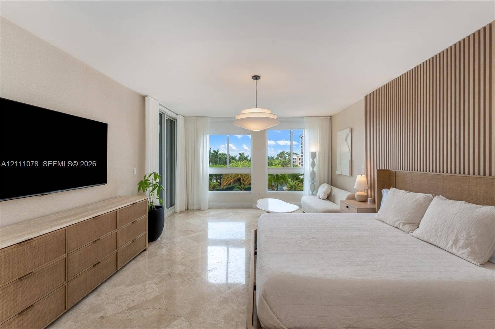 765 Crandon Boulevard, #311, Key Biscayne, FL 33149 Room featuring polished stone flooring, custom vertical slat wood wall paneling, built-in drawer cabinetry, and large-scale windows
