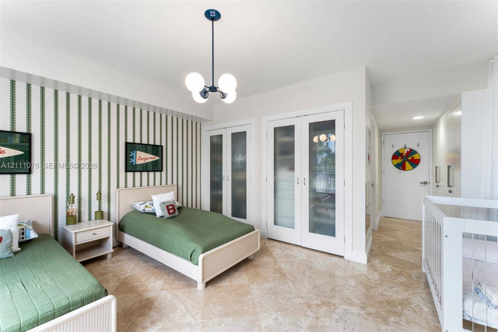 765 Crandon Boulevard, #311, Key Biscayne, FL 33149 Room featuring stone tile flooring, a modern four-globe chandelier, and double doors with frosted glass panels