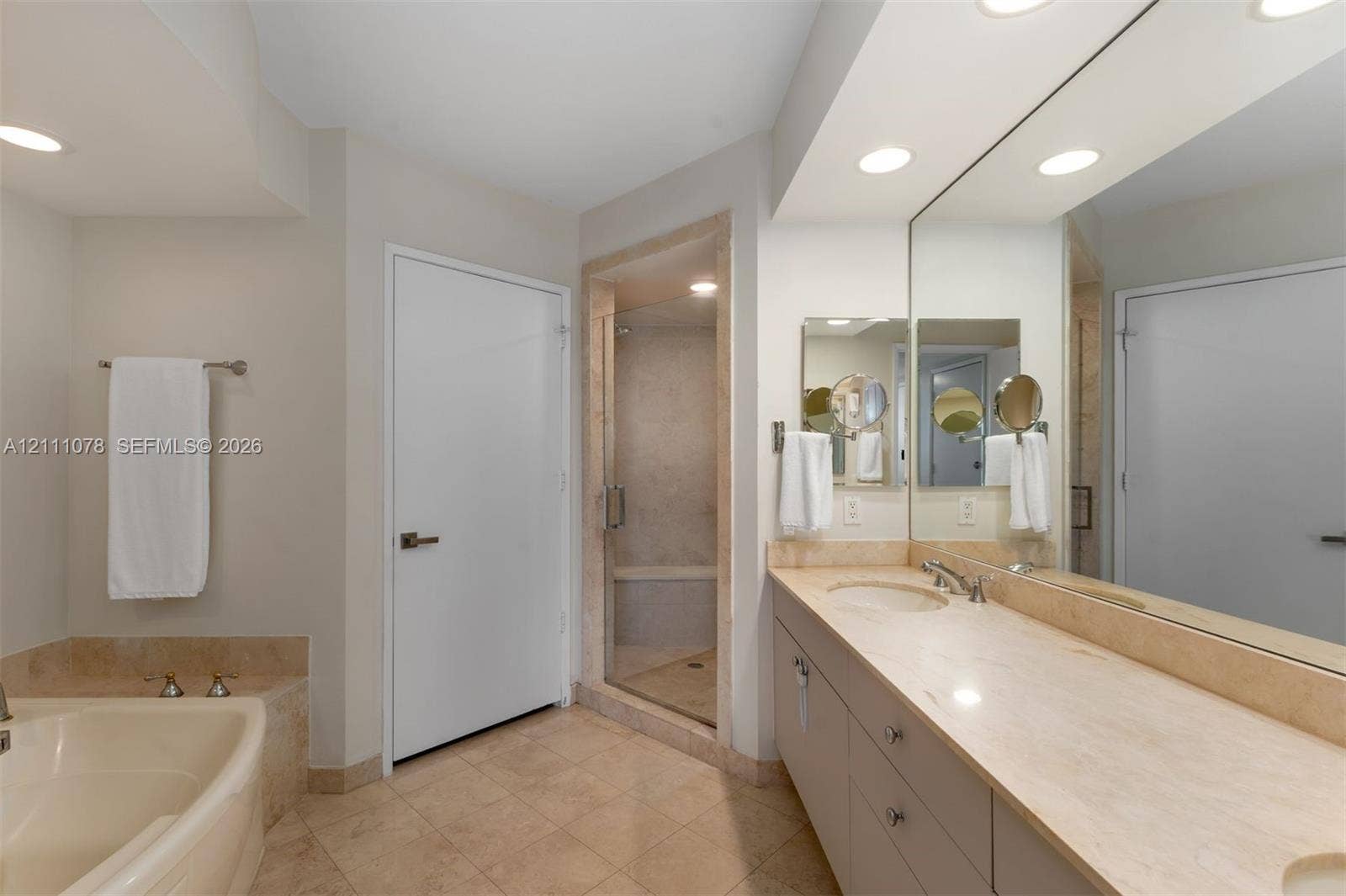 765 Crandon Boulevard, #311, Key Biscayne, FL 33149 Bathroom featuring a double vanity with a stone countertop, a glass-enclosed shower, a built-in soaking tub with stone surround, and recessed lighting