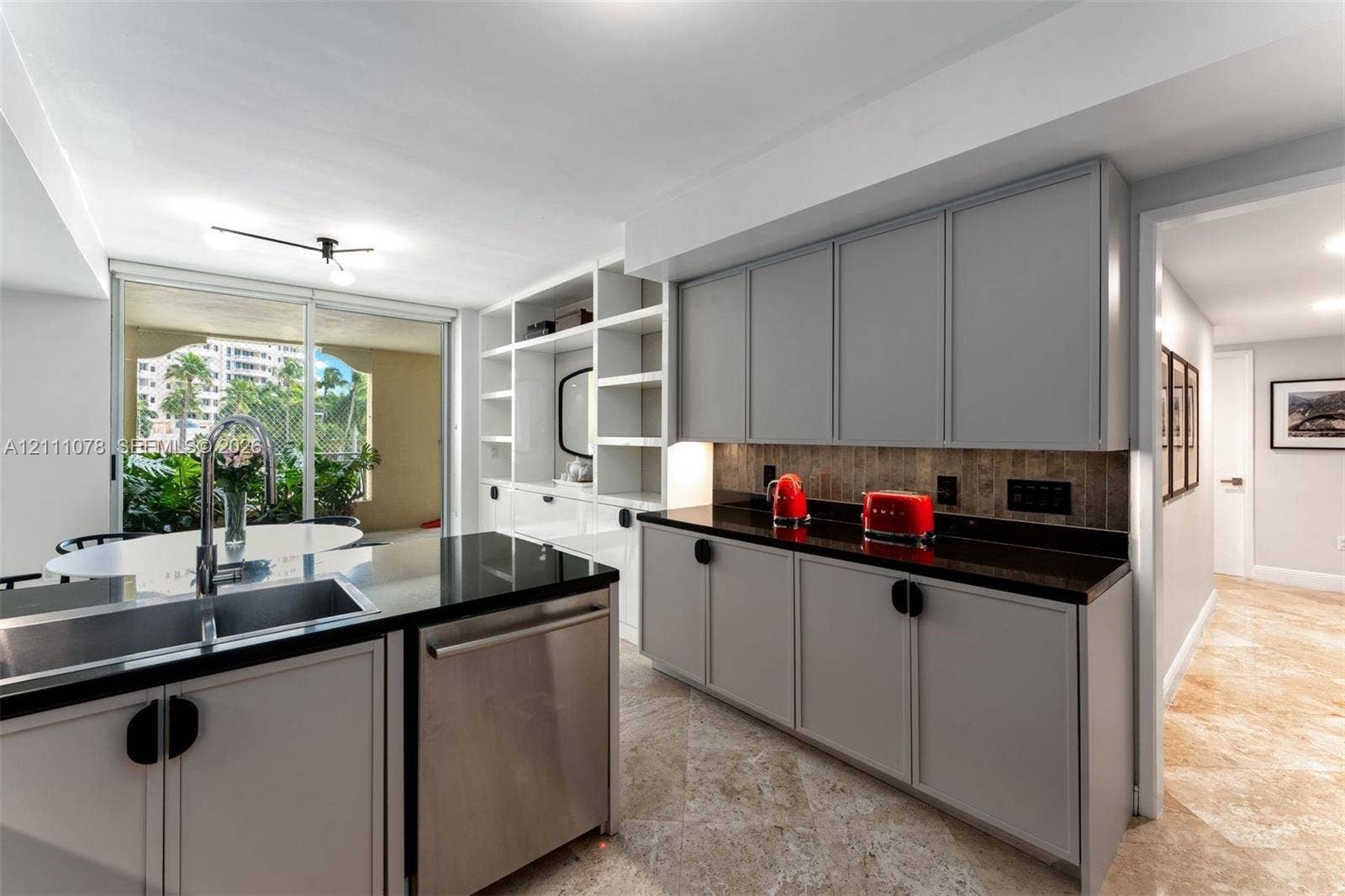 765 Crandon Boulevard, #311, Key Biscayne, FL 33149 Kitchen featuring grey cabinetry, stone-finish countertops, stainless steel undermount sink, built-in shelving unit, and stone flooring