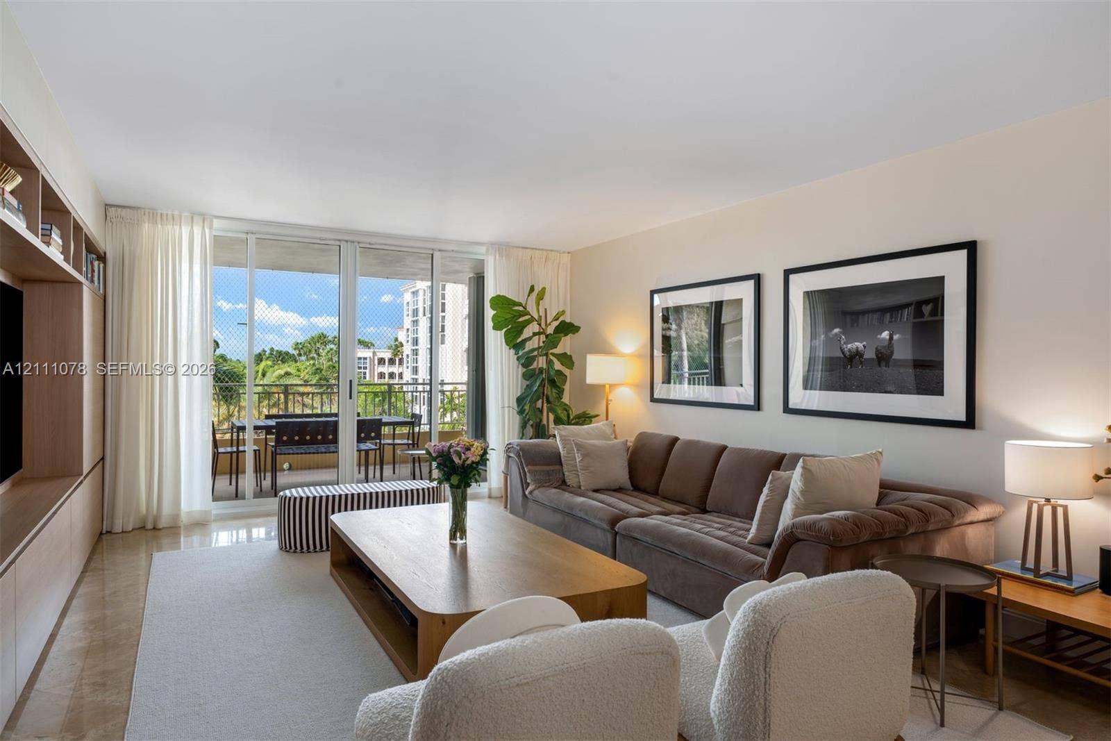 765 Crandon Boulevard, #311, Key Biscayne, FL 33149 Open-concept living space featuring floor-to-ceiling glass sliding doors, stone-finish flooring, and built-in floor-to-ceiling cabinetry