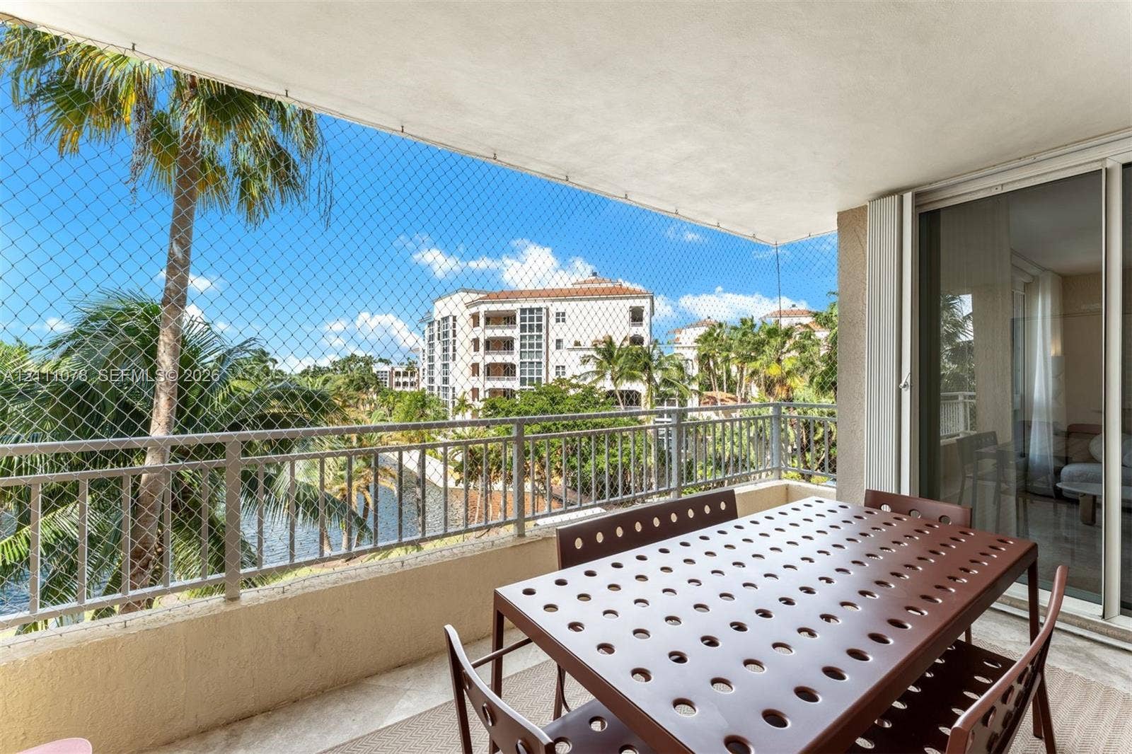 765 Crandon Boulevard, #311, Key Biscayne, FL 33149 Covered balcony with metal railing, stone-finish flooring, and sliding glass entry door