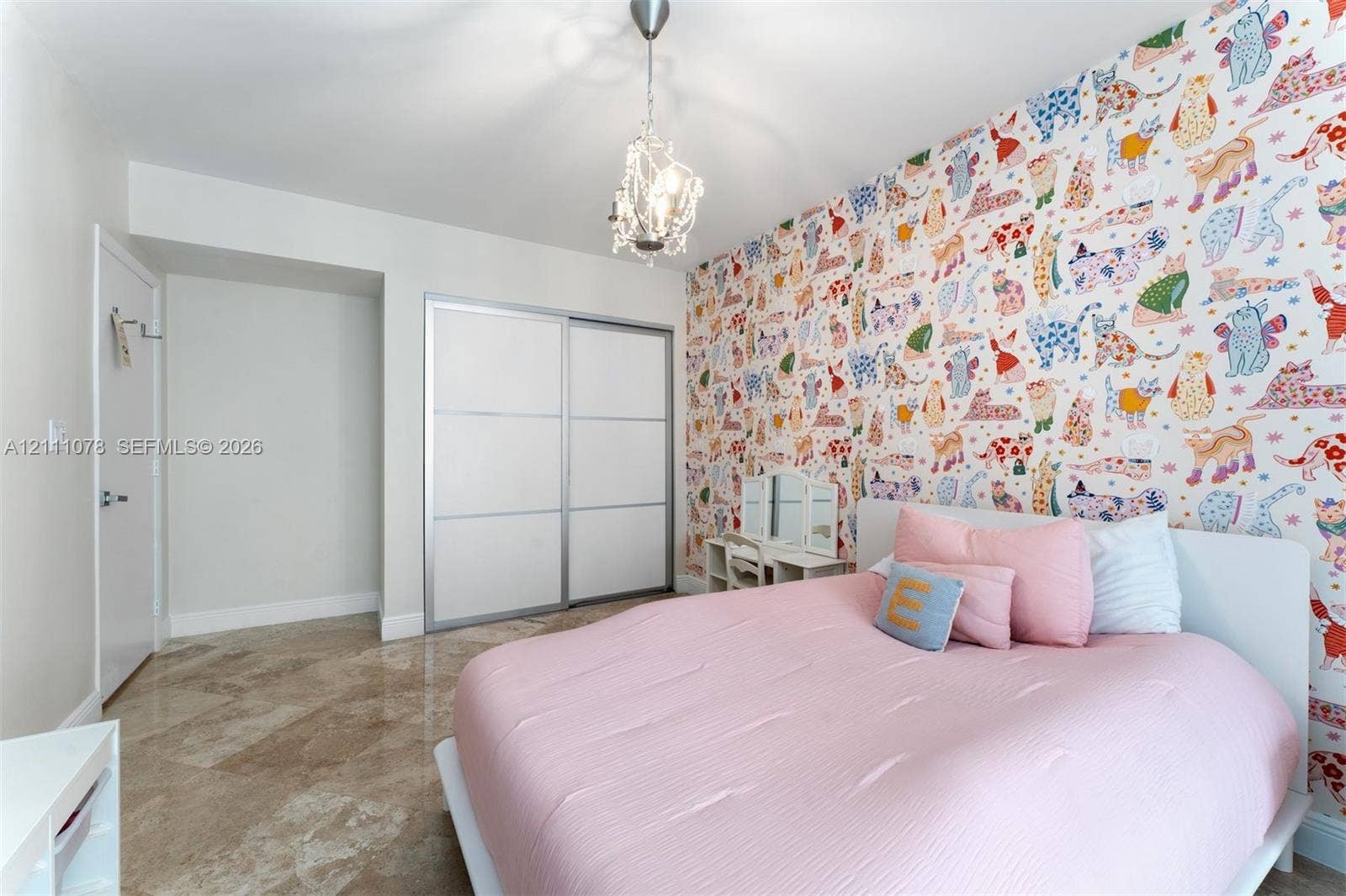 765 Crandon Boulevard, #311, Key Biscayne, FL 33149 Room featuring polished stone flooring, patterned wallpaper accent wall, dual-panel sliding closet doors, and a crystal-style drop pendant light