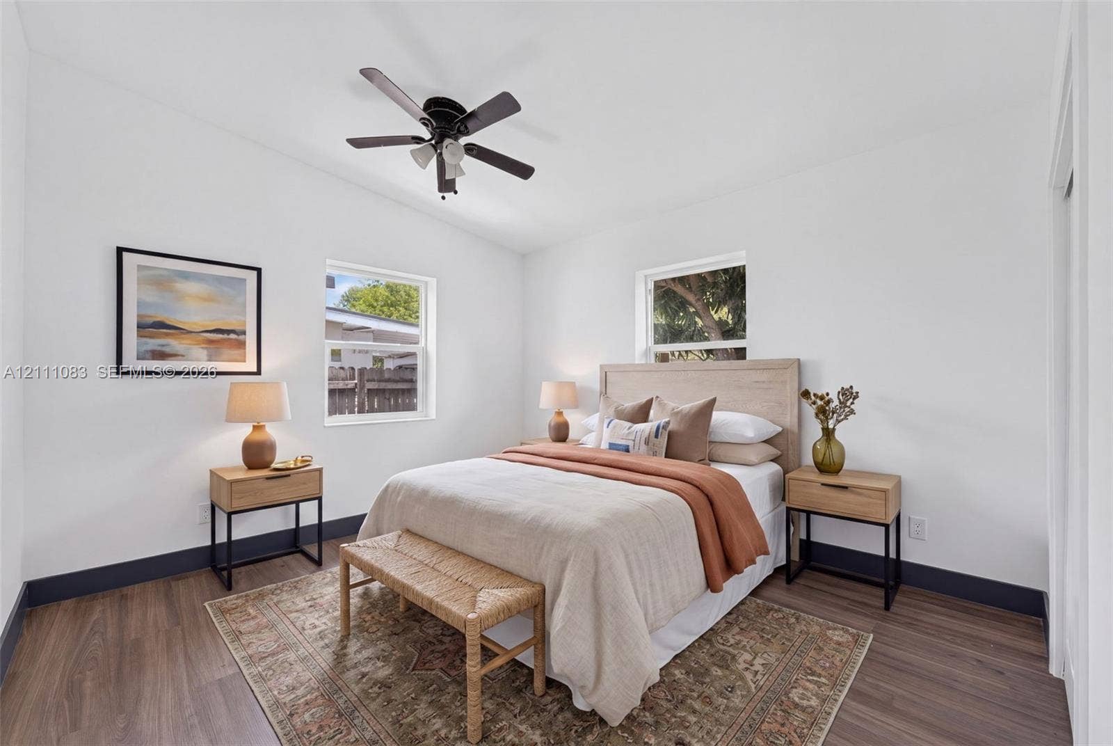 Wood-finish flooring, high ceilings, dual-pane windows, and a ceiling-mounted light fixture with a fan