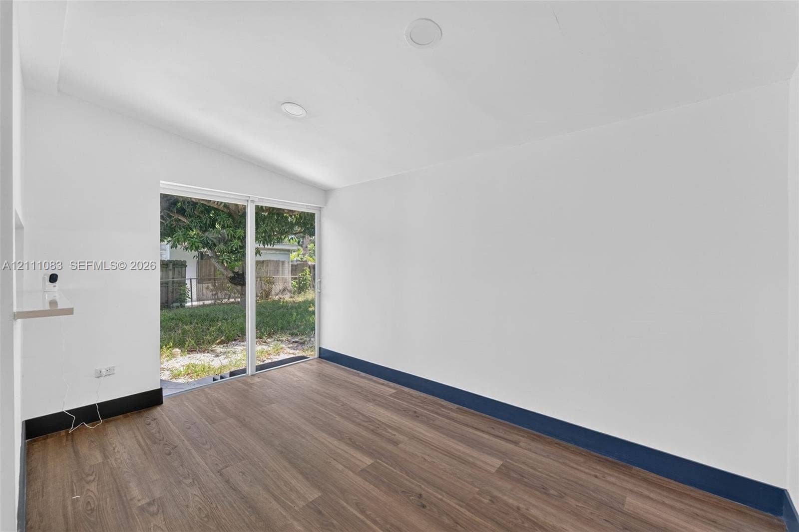 Shed-style ceiling featuring recessed lighting, wood-finish flooring, sliding glass door, and a built-in wall shelf