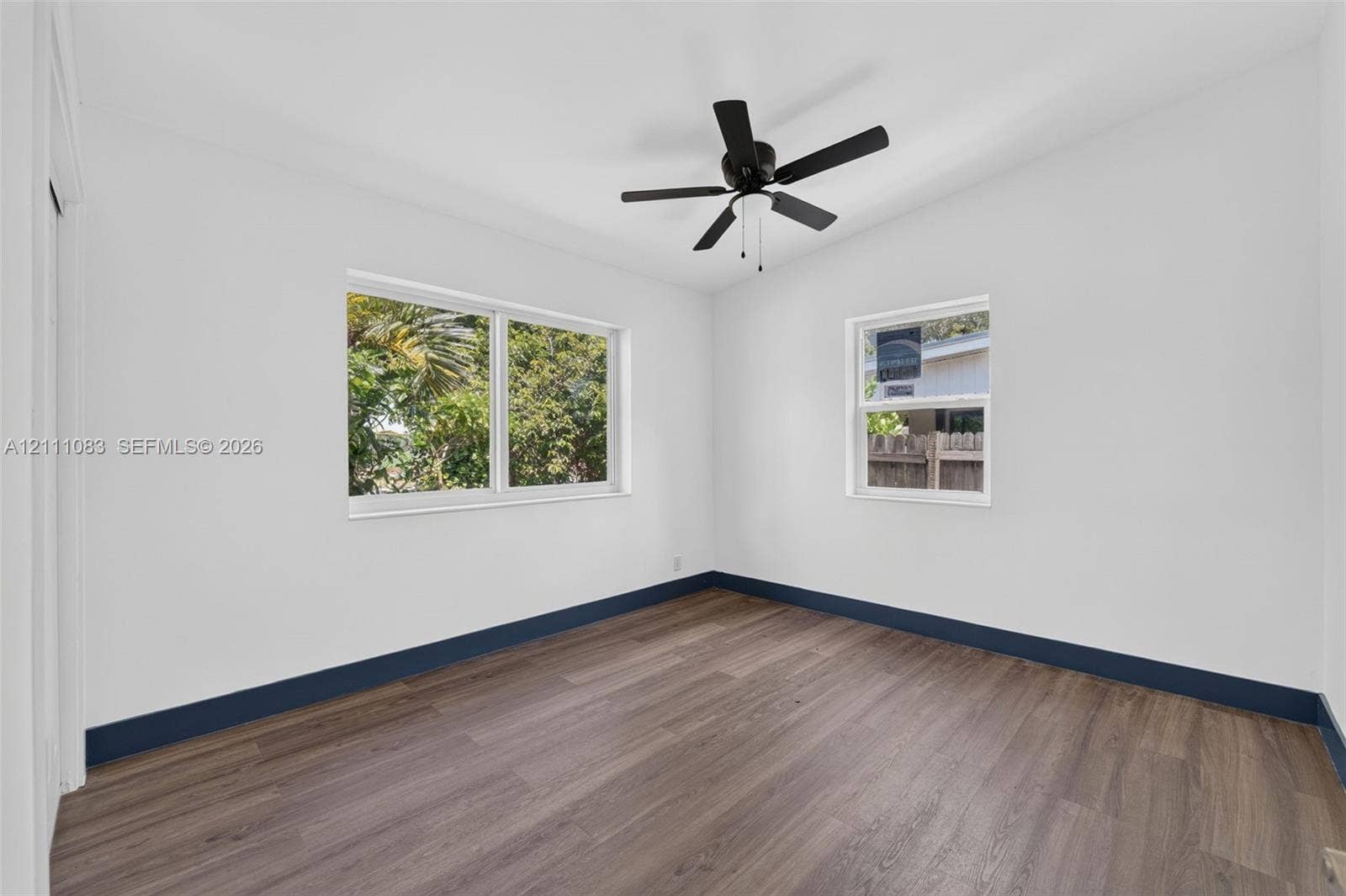 Neutral-toned interior featuring wood-finish flooring, dual-pane windows, and a ceiling-mounted light fixture