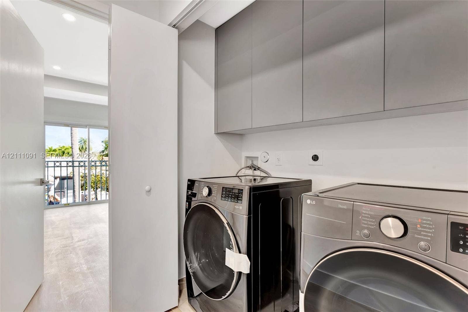 Laundry area featuring flat-panel upper cabinetry, recessed lighting, and tile flooring