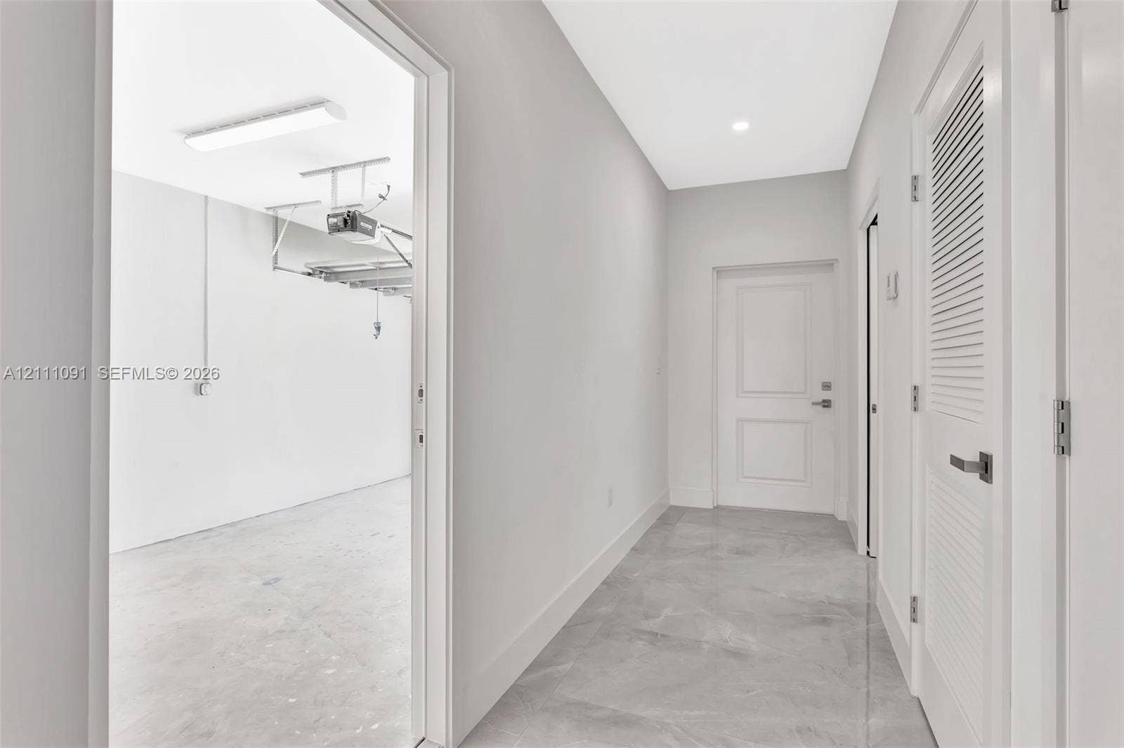 Neutral-toned tile flooring, solid-core interior doors, and a louvered mechanical closet door