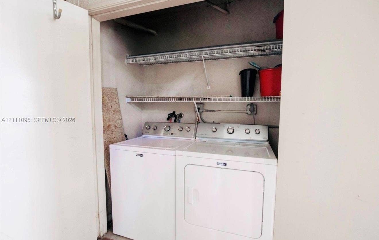 120 SW 96th Terrace, #104, Plantation, FL 33324 Utility closet featuring dual metal wire shelving units and dedicated laundry appliance hookups