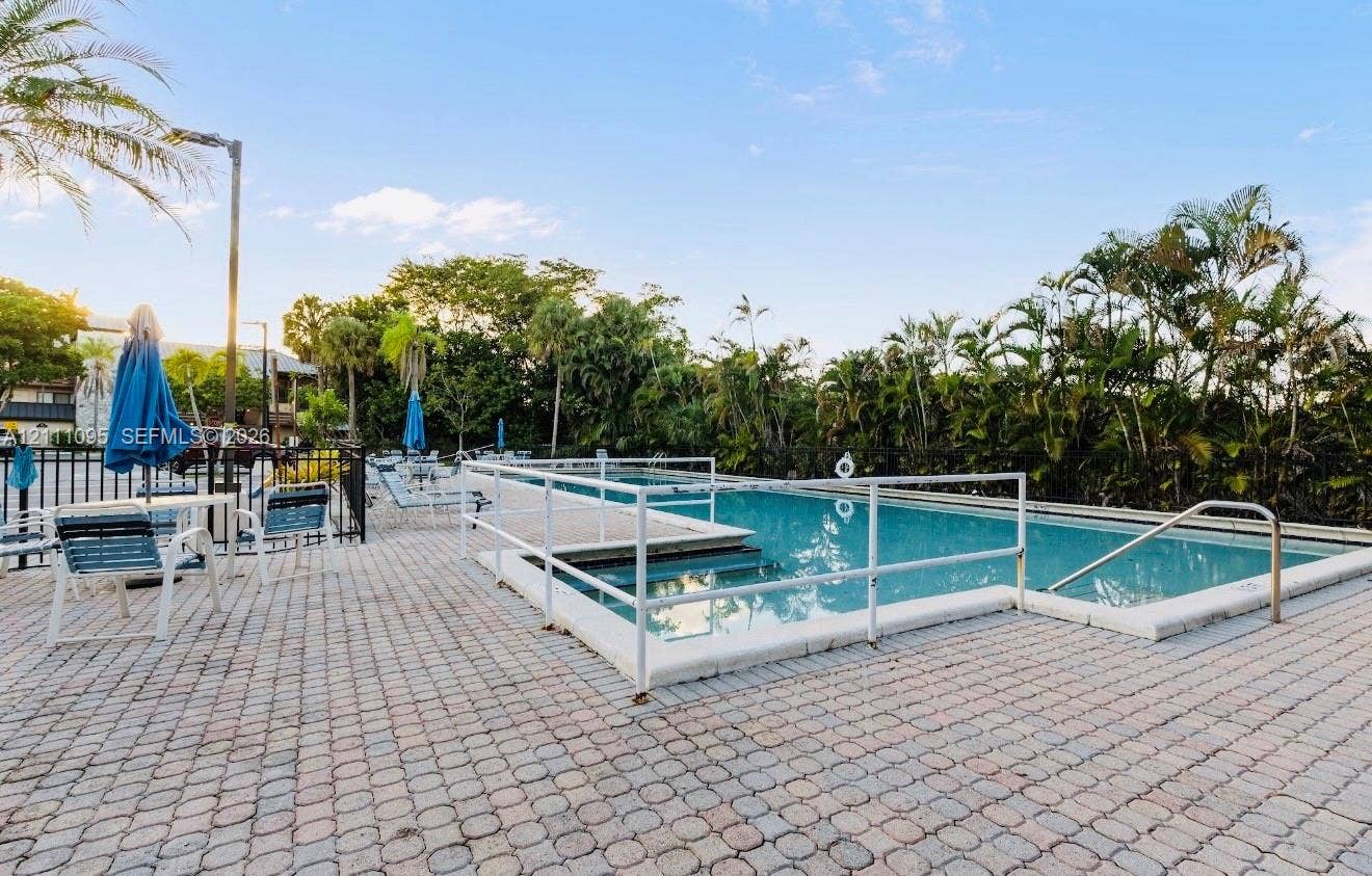 120 SW 96th Terrace, #104, Plantation, FL 33324 Swimming pool with white perimeter fencing, multi-level concrete decking, and integrated metal handrails