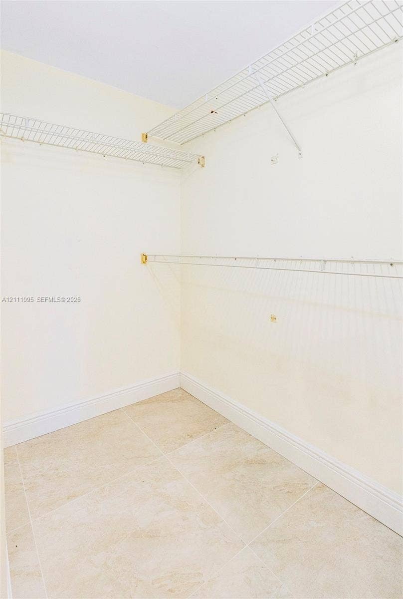 120 SW 96th Terrace, #104, Plantation, FL 33324 Walk-in closet featuring stone-finish tile flooring and multi-level wall-mounted wire shelving