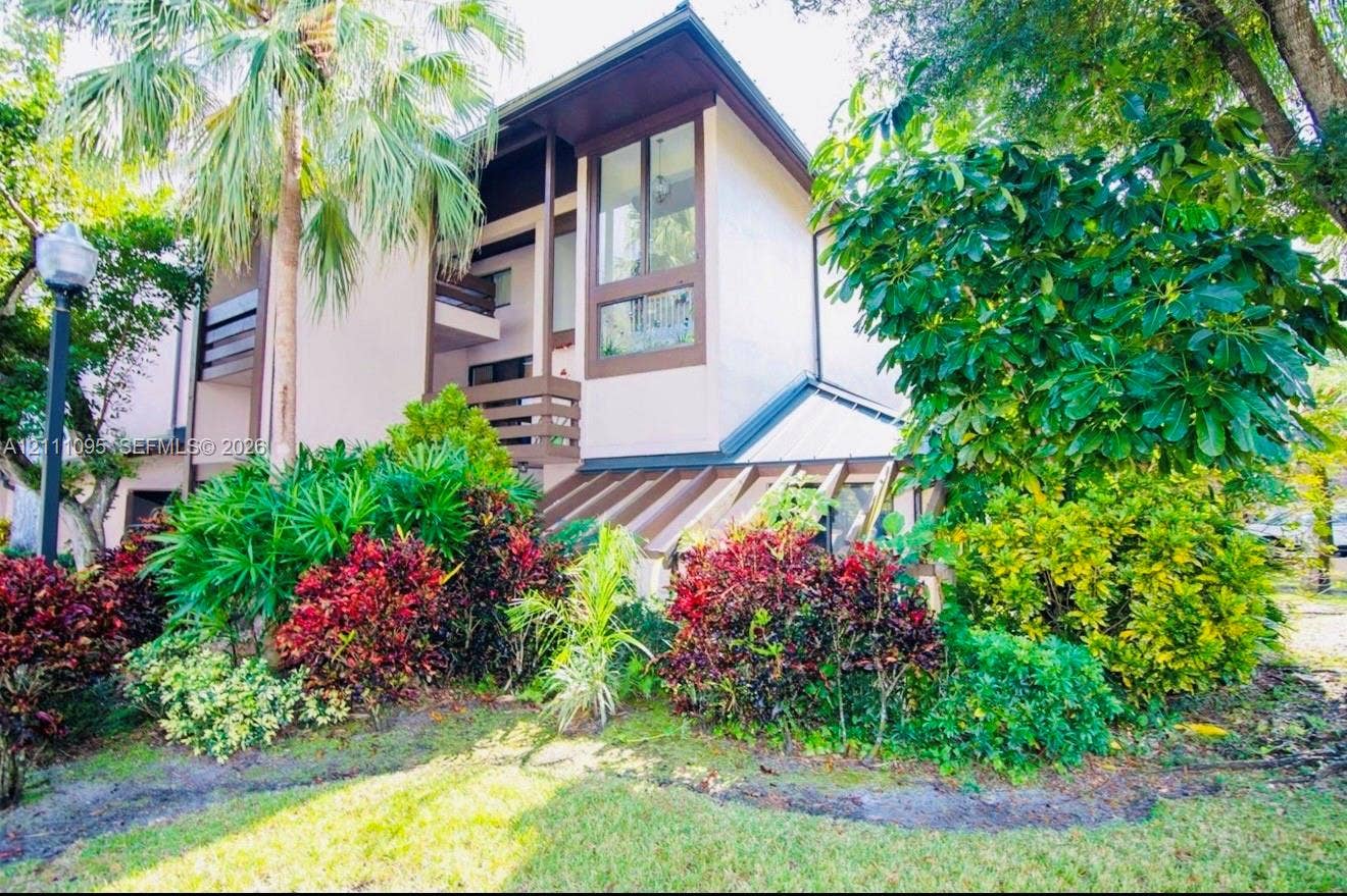 120 SW 96th Terrace, #104, Plantation, FL 33324 Exterior facade featuring multi-level balconies, oversized vertical windows, and a structured architectural design complemented by mature landscaping and diverse shrubbery