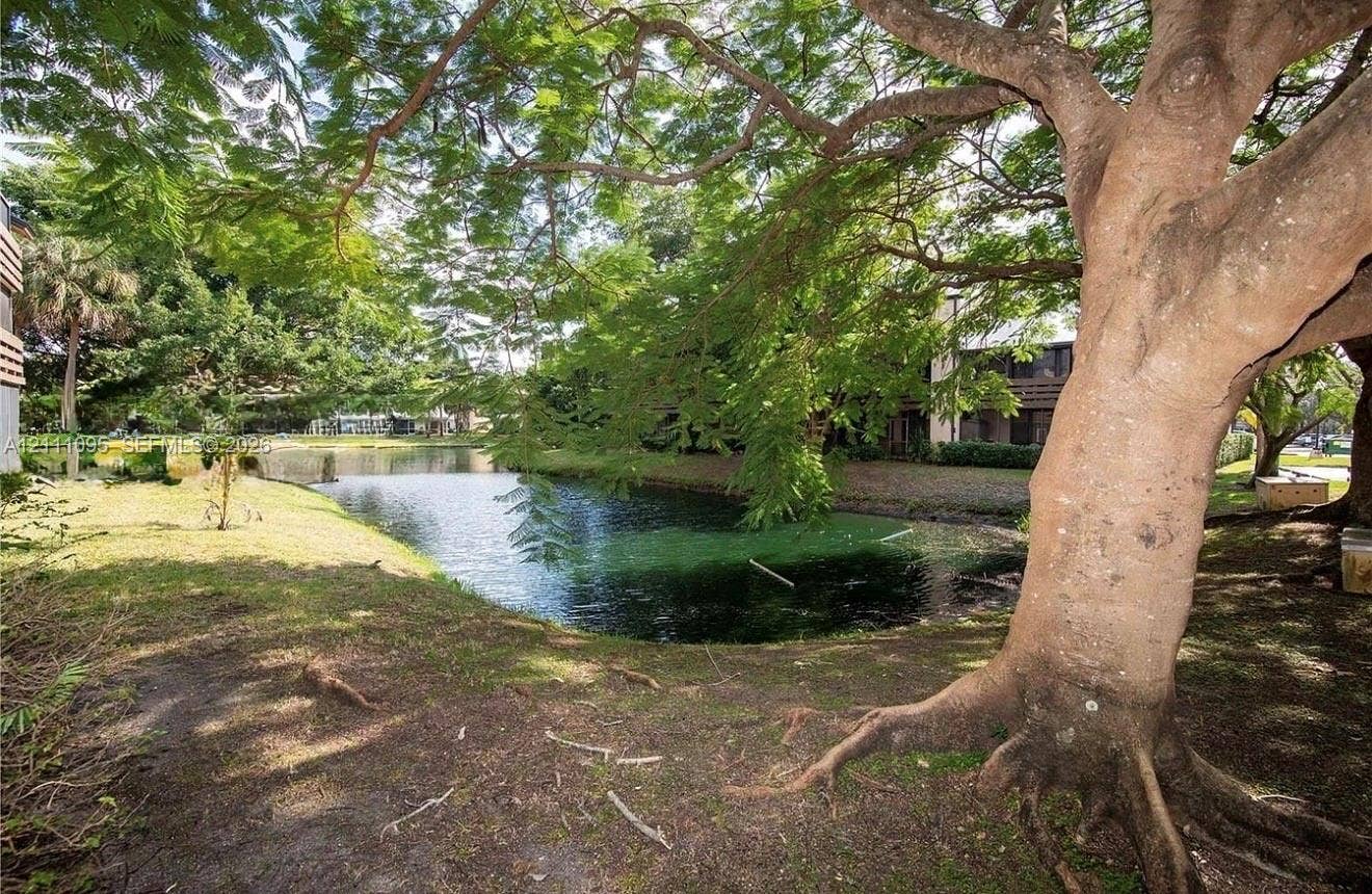 120 SW 96th Terrace, #104, Plantation, FL 33324 Waterfront lot featuring a natural pond, mature trees, and grass lawn