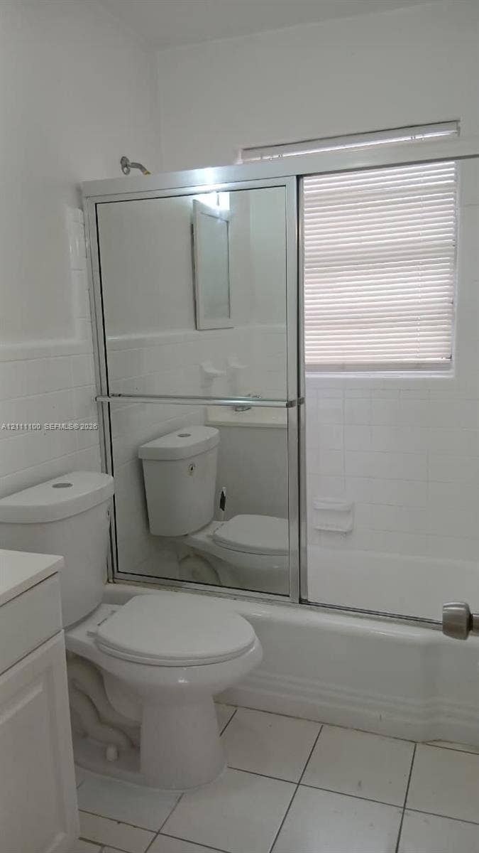 325 NE 2nd Street, #4, Hallandale Beach, Hallandale Beach, FL 33009 Full bathroom featuring white ceramic wall tiling, a combination bathtub and shower with a mirrored sliding enclosure, and white floor tiling