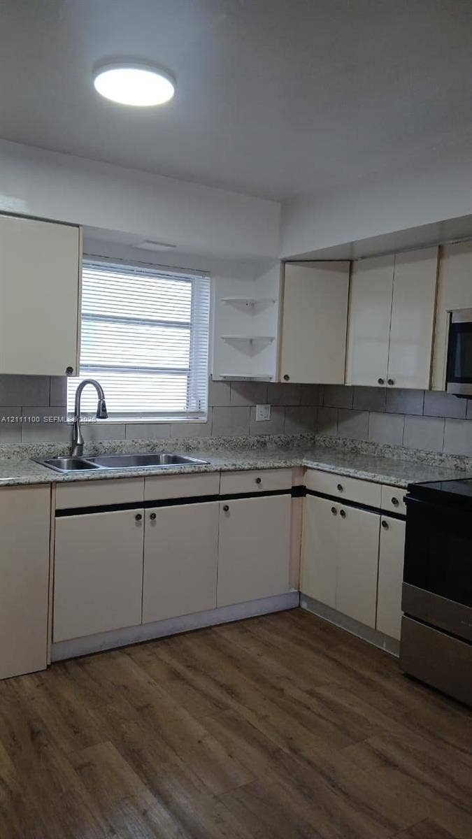 325 NE 2nd Street, #4, Hallandale Beach, Hallandale Beach, FL 33009 Kitchen featuring stone-finish countertops, wood-finish flooring, undermount dual-basin sink with arched faucet, and built-in cabinetry with open corner shelving