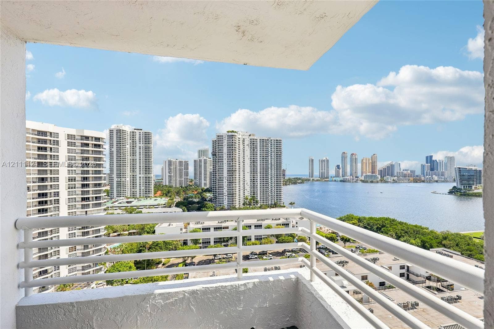 3300 NE 192nd Street, #1813, Aventura, FL 33180 Private balcony with a white horizontal railing overlooking a cityscape, waterfront, and marina