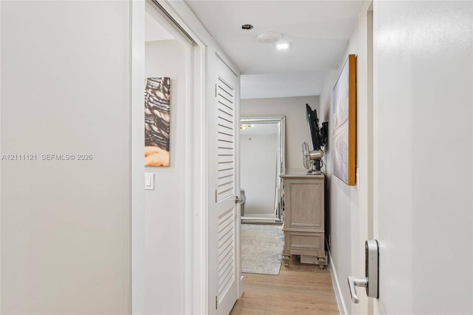 3300 NE 192nd Street, #1813, Aventura, FL 33180 Louvered door, wood-finish flooring, and recessed ceiling lighting entry to guest bedroom