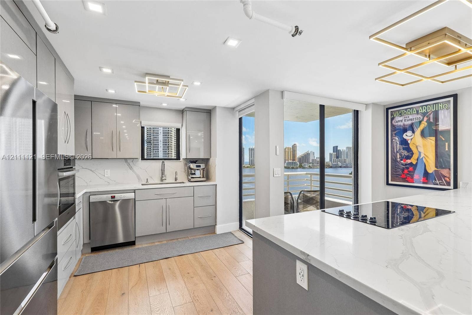 3300 NE 192nd Street, #1813, Aventura, FL 33180 Kitchen featuring high-gloss cabinetry, stone-surface countertops, wood-finish flooring, stainless steel appliances, and integrated geometric lighting fixtures