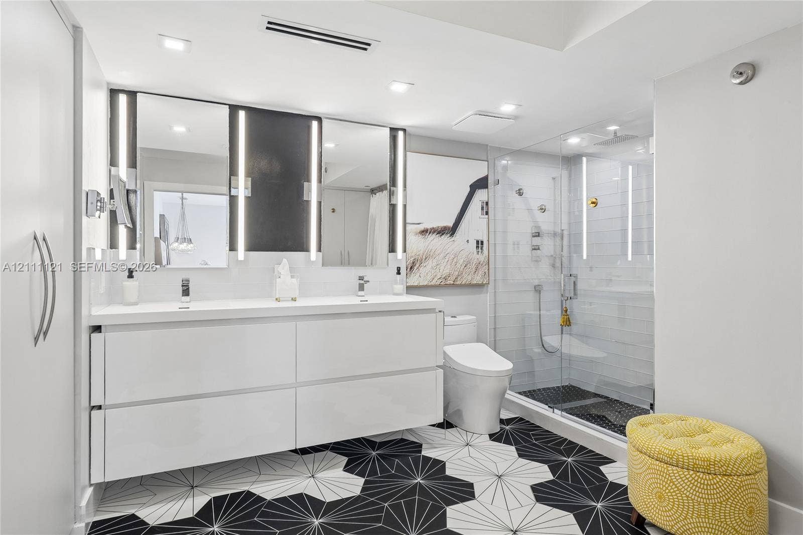 3300 NE 192nd Street, #1813, Aventura, FL 33180 Floating double vanity with integrated sinks, geometric patterned floor tile, glass-enclosed shower with horizontal wall tile, and recessed lighting