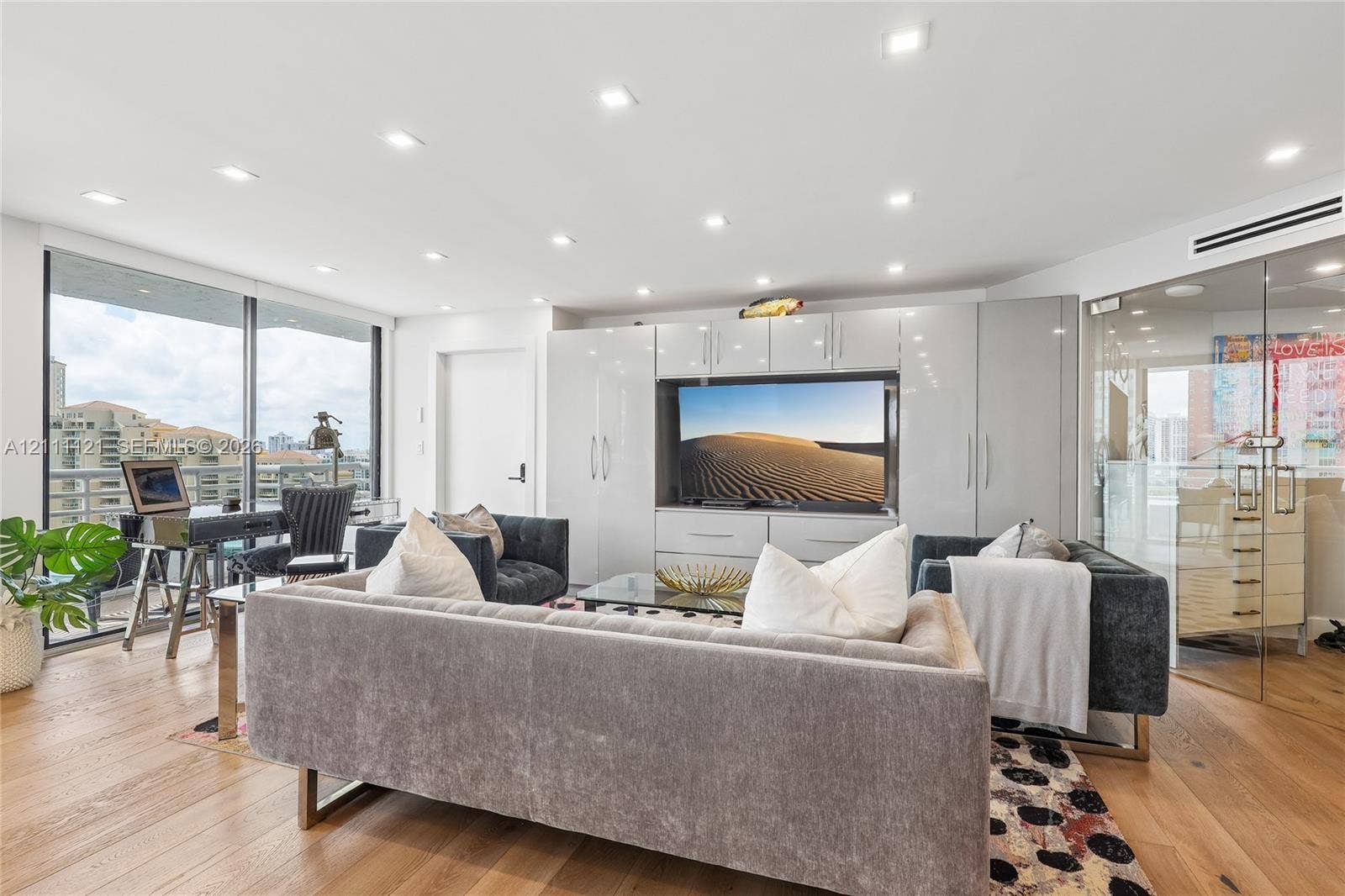 3300 NE 192nd Street, #1813, Aventura, FL 33180 Living area featuring wood-finish flooring, recessed lighting, floor-to-ceiling windows, integrated white cabinetry, and a glass-enclosed partitioned space