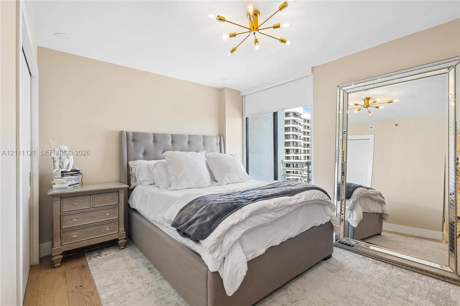 3300 NE 192nd Street, #1813, Aventura, FL 33180 Gold-tone multi-arm chandelier, large floor-to-ceiling windows, roller shades, and wood-finish flooring
