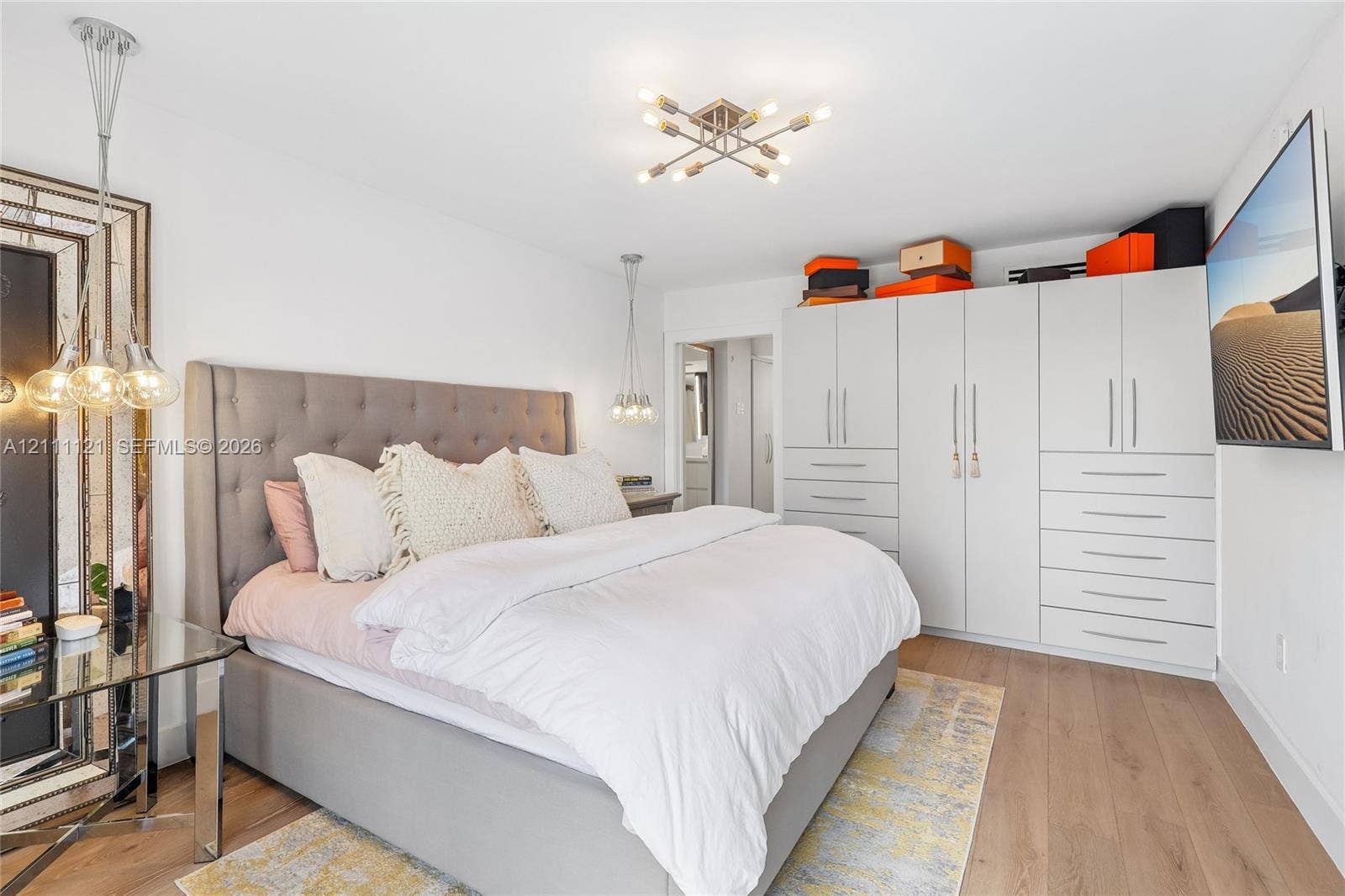 3300 NE 192nd Street, #1813, Aventura, FL 33180 Room featuring wood-finish flooring, built-in floor-to-ceiling cabinetry, multi-light ceiling fixture, and dual hanging pendant lights
