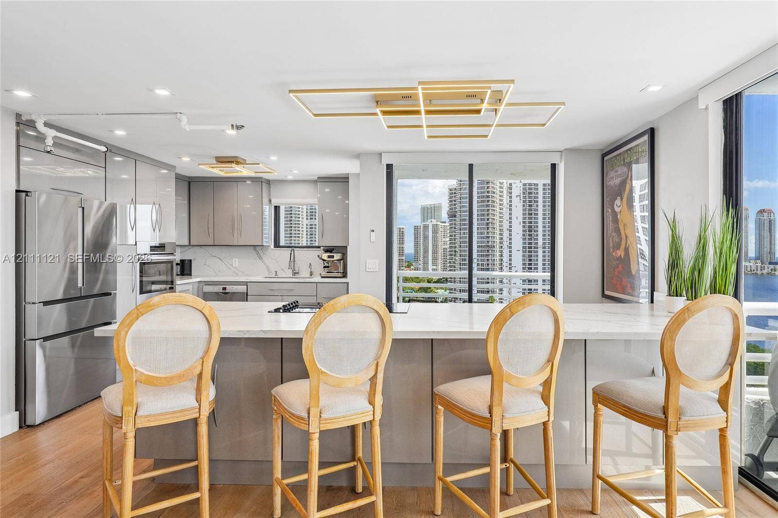 3300 NE 192nd Street, #1813, Aventura, FL 33180 Kitchen featuring a central island with a stone-surface countertop, high-gloss cabinetry, stainless steel appliances, and contemporary geometric ceiling lighting