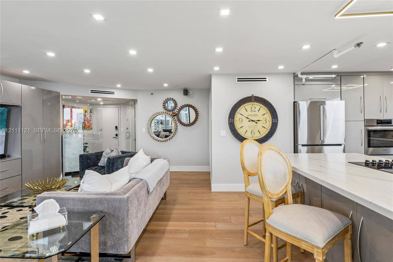 3300 NE 192nd Street, #1813, Aventura, FL 33180 Open-concept interior featuring light wood-finish flooring, recessed lighting, and a kitchen island with a white countertop