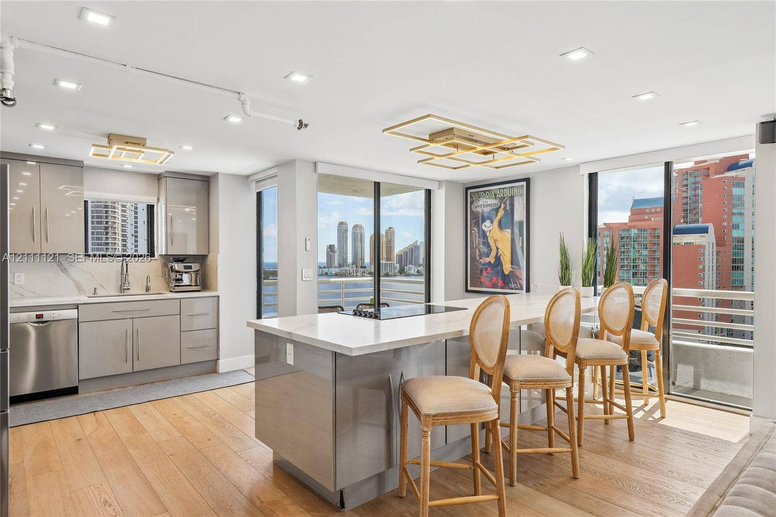 3300 NE 192nd Street, #1813, Aventura, FL 33180 Contemporary kitchen featuring wood-finish flooring, high-gloss cabinetry, a quartz waterfall island, recessed lighting, and floor-to-ceiling glass sliding doors