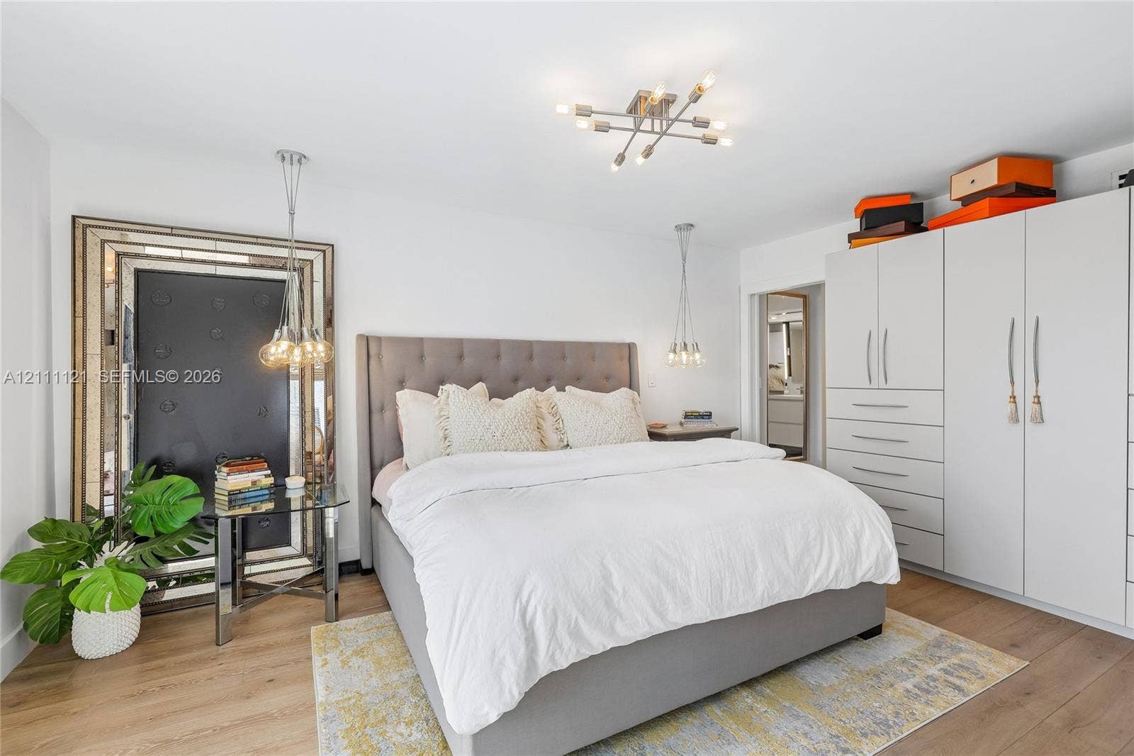 3300 NE 192nd Street, #1813, Aventura, FL 33180 Floor-to-ceiling built-in cabinetry, wide-plank wood-finish flooring, multi-arm ceiling fixture, and dual pendant lights