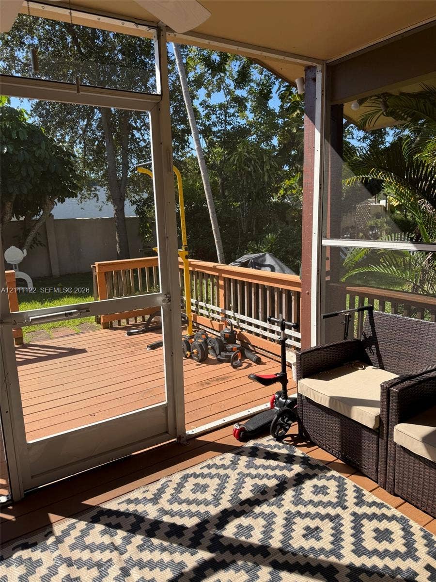 Screened-in porch featuring a wood-toned deck and a solid-surface ceiling