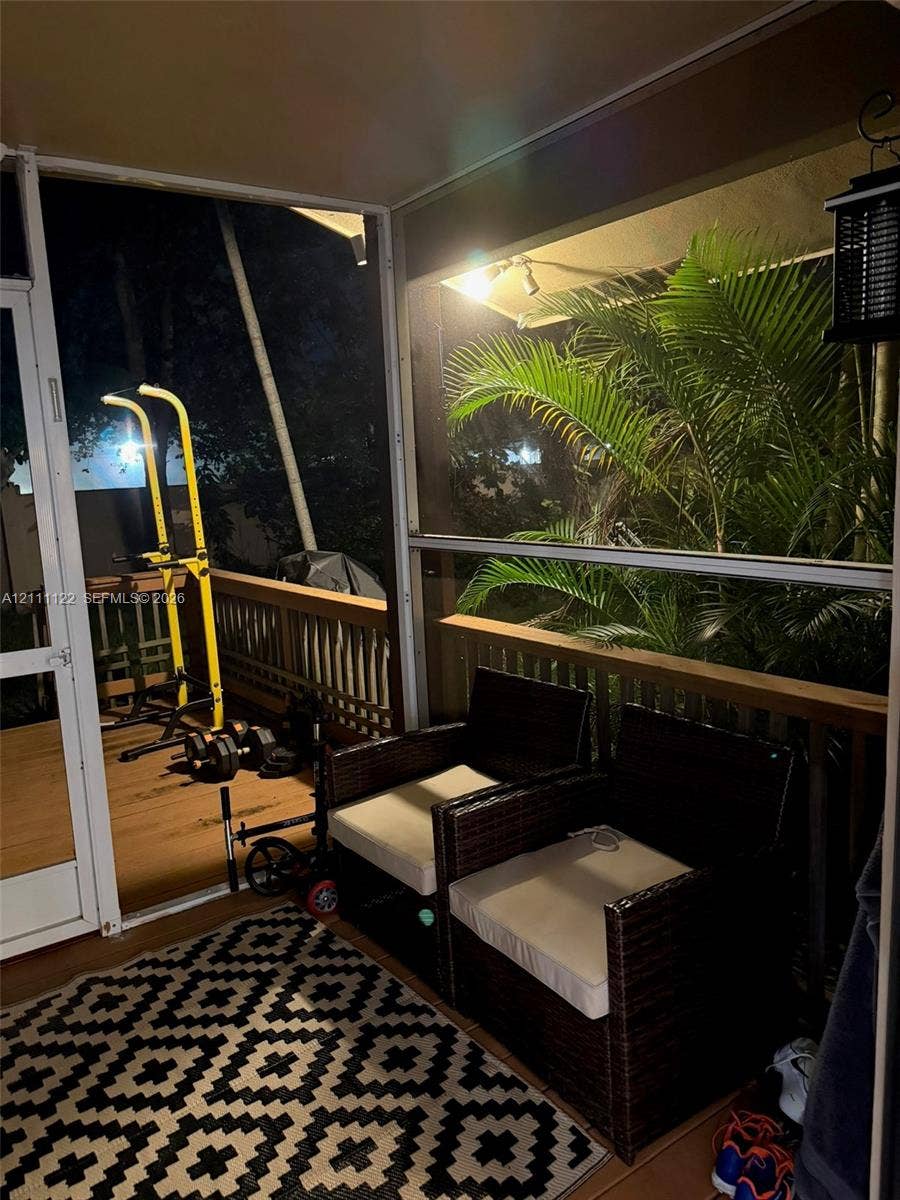 Screened-in porch featuring wood-tone decking and a perimeter railing
