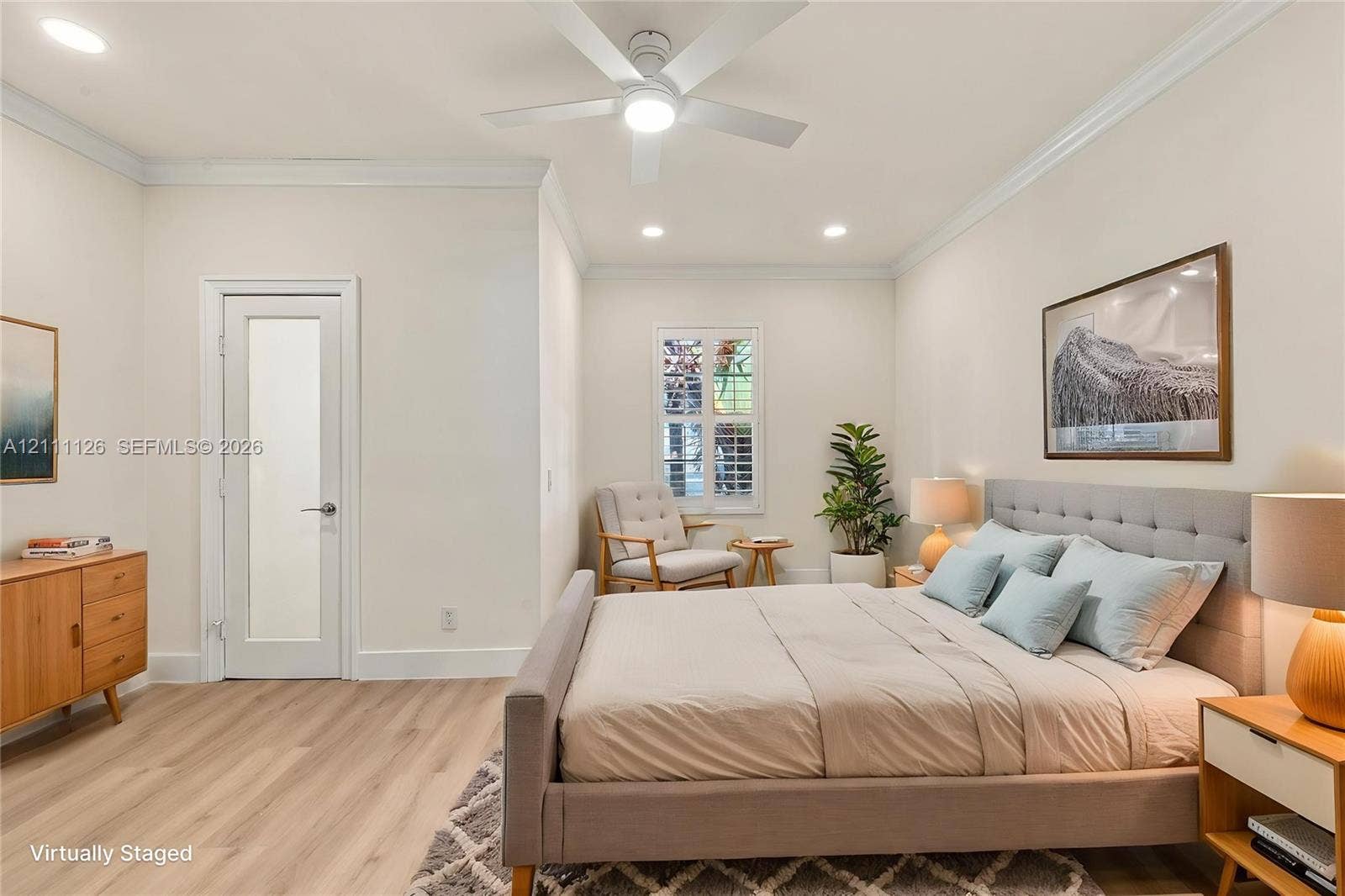 Neutral interior featuring wood-finish flooring, recessed lighting, crown molding, a ceiling fan, and a door with a frosted glass pane
