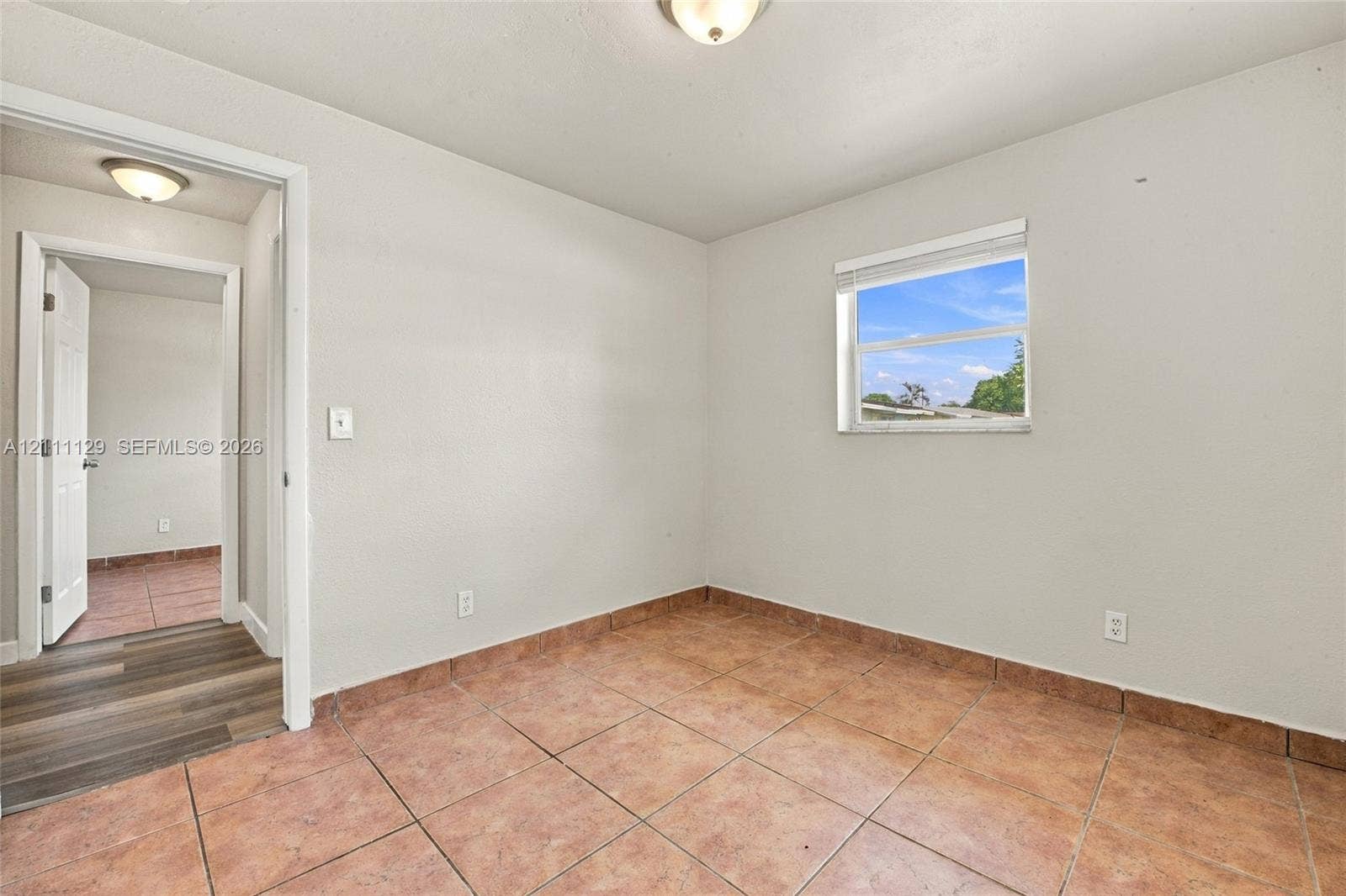 Room featuring ceramic tile flooring, neutral wall paint, and a single-pane window