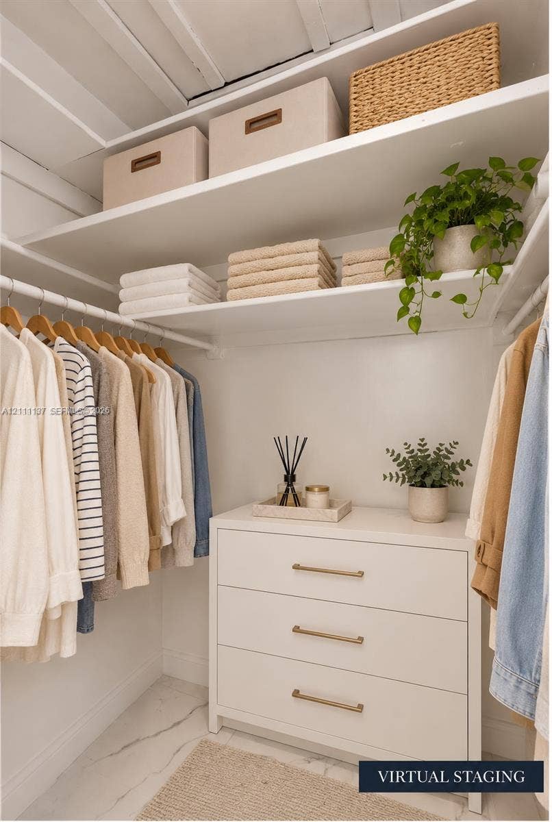 635 8th Street, #205, Miami Beach, Miami Beach, FL 33139 Walk-in closet featuring tiered white shelving, a built-in three-drawer dresser with metallic hardware, and white stone-finish flooring